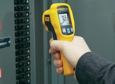 Compact Infrared Thermometer With Laser In Man's Hand