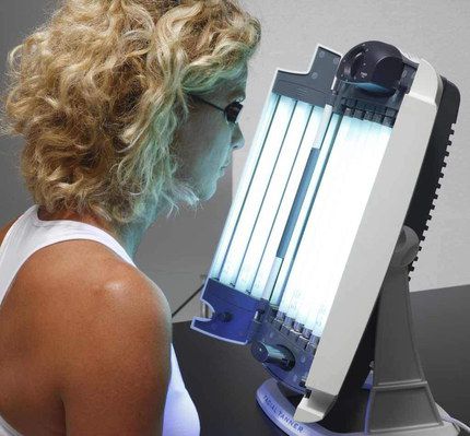 Face Tanning Lamp Used By Blonde Woman